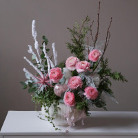 Зимняя композиция с розовыми ранункулюсами и декоративной зеленью в кашпо