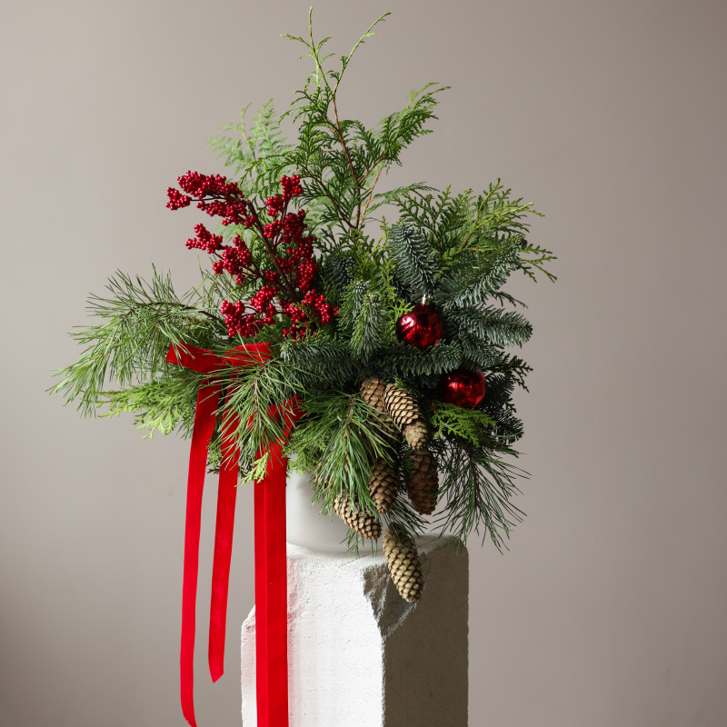 Новогодний букет из живой хвои с шишками, красными ягодами и бантами в кашпо