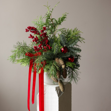 Новогодний букет из живой хвои с шишками, красными ягодами и бантами в вазе матовое стекло