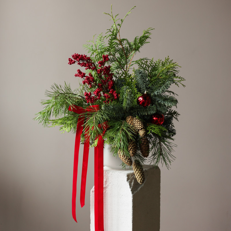 Новогодний букет из живой хвои с шишками, красными ягодами и бантами в кашпо