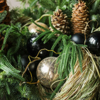 Композиция из живой хвои с золотыми и черными шариками и кедровыми шишками
