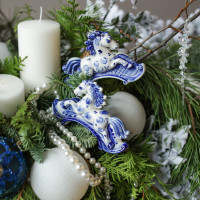 Композиция из живой хвои со свечами и лошадками гжель