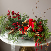 Композиция из живой хвои с красными свечами и золотой лошадкой-качалкой