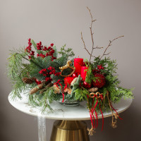 Композиция из живой хвои с красными свечами и золотой лошадкой-качалкой