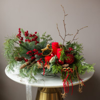 Композиция из живой хвои с красными свечами и золотой лошадкой-качалкой