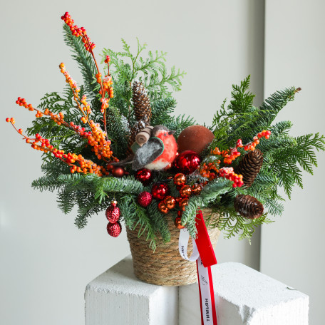 Композиция из живой хвои с оранжевым декором и снегирем