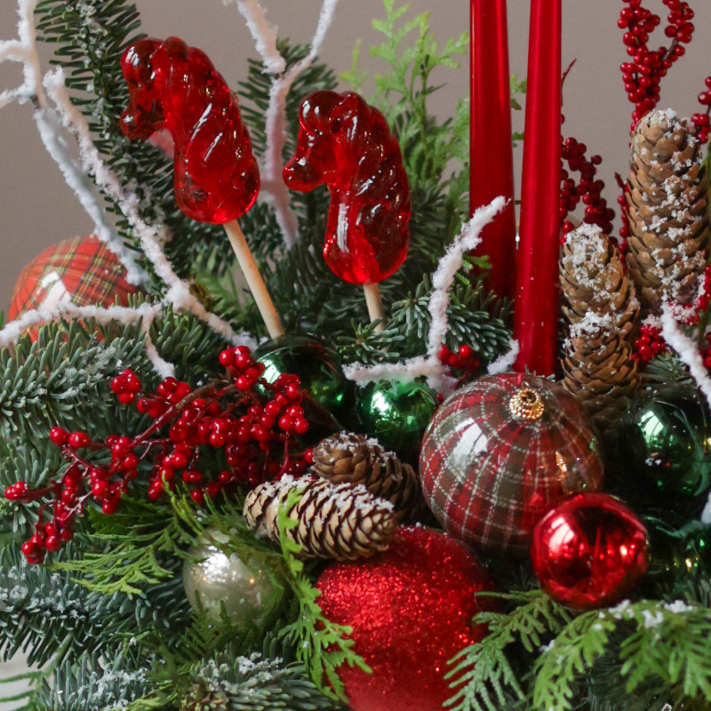 Композиция с красными лошадками-леденцами и высокими свечами