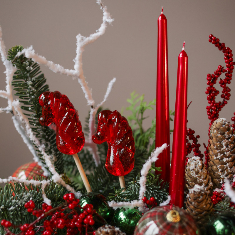 Композиция с красными лошадками-леденцами и высокими свечами