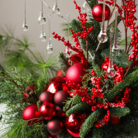 Новогодняя композиция с красным декором, ягодками и стеклянными каплями на декоративных ветках