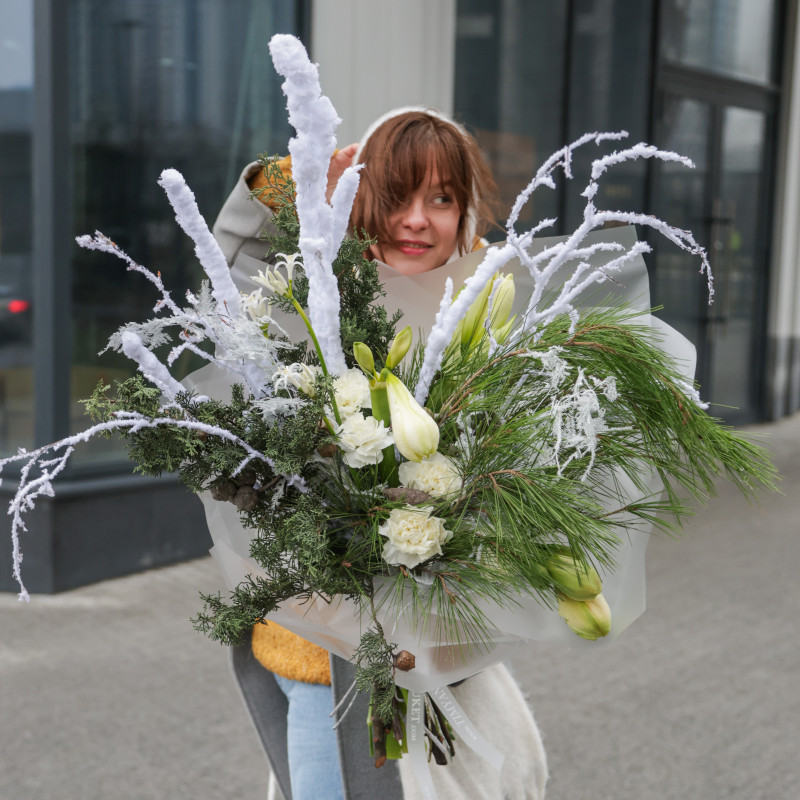 Зимний букет с хвоей, заснеженными ветками и белыми амариллисами