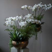 Композиция с белыми орхидеями (ботаническая копия) и зеленью в дизайнерском кашпо (металл), L