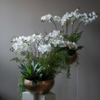 Композиция с белыми орхидеями (ботаническая копия) и зеленью в дизайнерском кашпо (металл), L