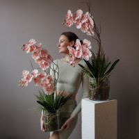 Композиция с розовыми орхидеями и зеленью в стеклянном цилиндре