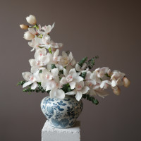 Белые орхидеи в дизайнерской вазе с эвкалиптом