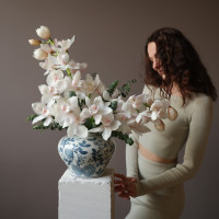 Белые орхидеи в дизайнерской вазе с эвкалиптом