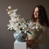 Белые орхидеи в дизайнерской вазе с эвкалиптом