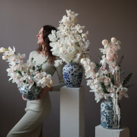 Белые орхидеи в дизайнерской вазе с эвкалиптом