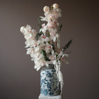 Белые орхидеи в дизайнерской вазе с эвкалиптом и стабилизированным амарантом