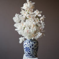 Белые орхидеи в дизайнерской вазе со стабилизированным аспарагусом