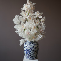 Белые орхидеи в дизайнерской вазе со стабилизированным аспарагусом