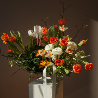 Композиция на парящей стеклянной подставке с тюльпанами, цикламенами и ранункулюсами