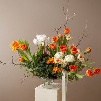 Композиция на парящей стеклянной подставке с тюльпанами, цикламенами и ранункулюсами