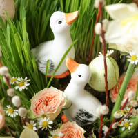 Пасхальная композиция с белыми уточками и ранункулюсами в стеклянном низком кашпо