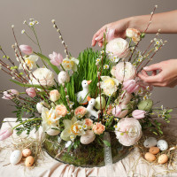 Пасхальная композиция с белыми уточками и ранункулюсами в стеклянном низком кашпо