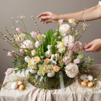 Пасхальная композиция с белыми уточками и ранункулюсами в стеклянном низком кашпо