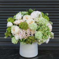 Круглая композиция пудрово-лаймовых оттенков в дизайнерской вазе