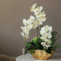 Композиция с белыми орхидеями и декоративной зеленью в дизайнерской золотой вазе 