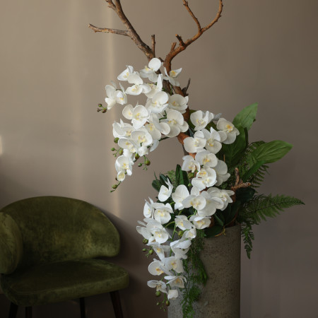 WOW-композиция с белыми орхидеями, декоративной зеленью и веткой в высокой бетонной вазе