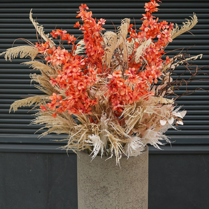 Композиция в стиле сухоцветов с оранжевыми акцентами в высоком бетонном кашпо