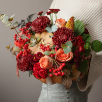 Осенняя композиция в настоящей тыкве с винными хризантемами и ягодами