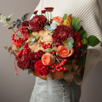 Осенняя композиция в настоящей тыкве с винными хризантемами и ягодами