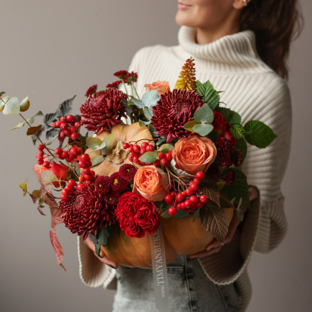 Осенняя композиция в настоящей тыкве с винными хризантемами и ягодами