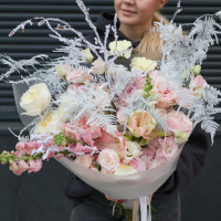 Зимний букет с заснеженными декоративными ветками, амариллисами, пионовидными розами