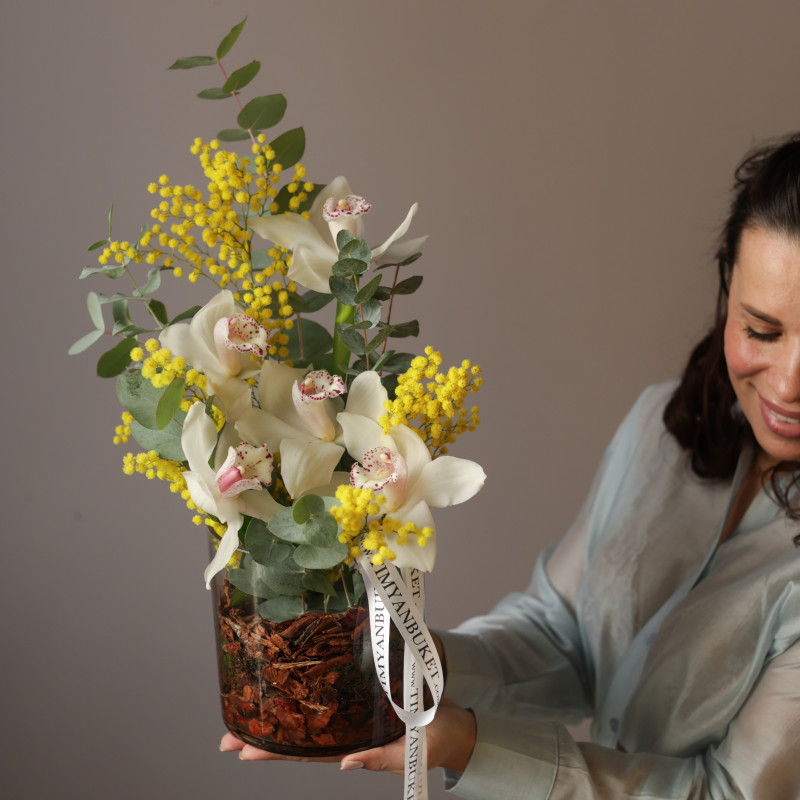 Орхидеи с мимозой и эвкалиптом в стеклянном цилиндре