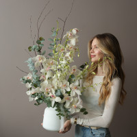 Белая орхидея в вазе с эвкалиптом