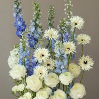 Композиция высокая с дельфиниумом, ранункулюсами и герберами