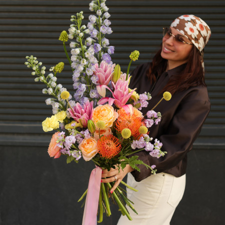 Яркий букет с дельфиниумом и пионовидными розами и лилиями  
