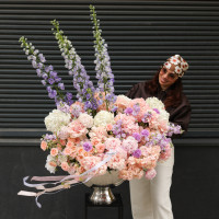 Композиция в вазе-шампаннице с гортензией, миксом роз и дельфиниумом